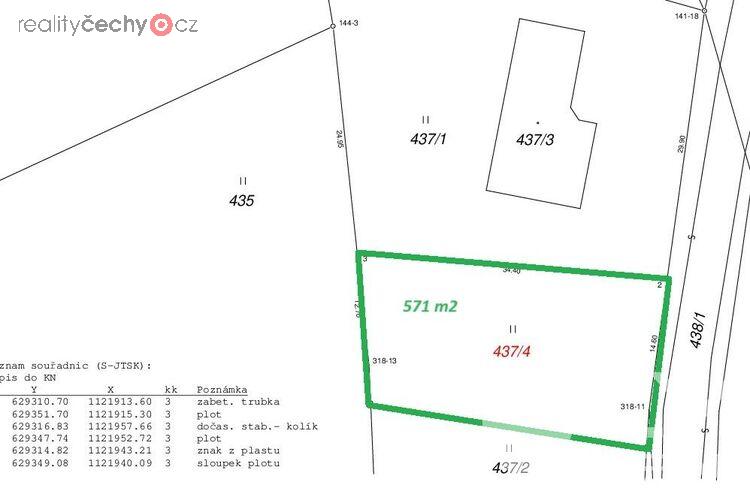 Příjezdová asfaltová komunikace, vpravo živý plot a budoucí vjezd k pozemku